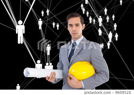 Composite image of serious architect holding plans and hard hat Composite image of serious architect holding plans and hard hat 9609528