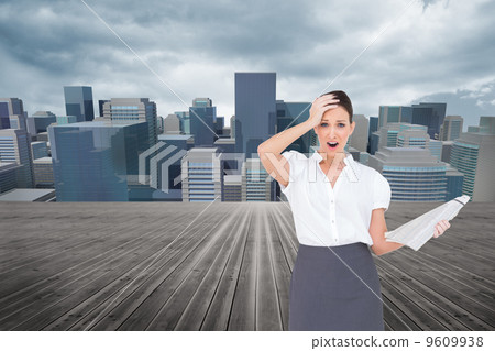Composite image of shocked classy businesswoman holding newspape Composite image of shocked classy businesswoman holding newspape 9609938