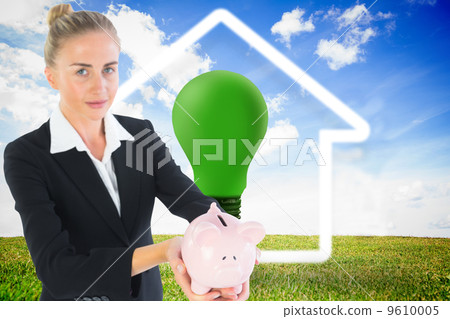 Composite image of businesswoman holding piggy bank Composite image of businesswoman holding piggy bank 9610005