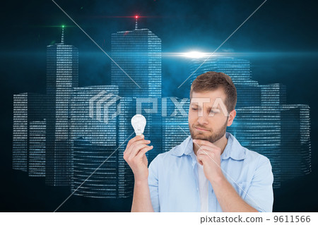 Composite image of sceptical model holding a bulb Composite image of sceptical model holding a bulb 9611566