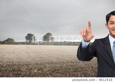 Composite image of smiling asian businessman pointing 9612418