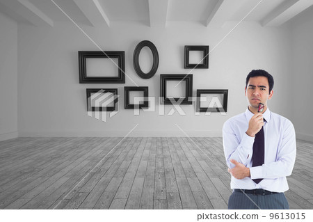 Composite image of thinking businessman holding glasses Composite image of thinking businessman holding glasses 9613015