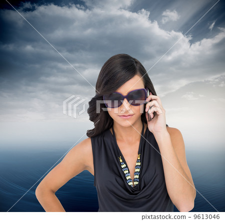 Composite image of serious elegant brunette wearing sunglasses o Composite image of serious elegant brunette wearing sunglasses o 9613046
