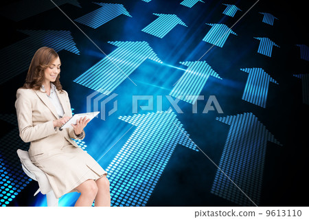 Composite image of happy businesswoman using tablet 9613110