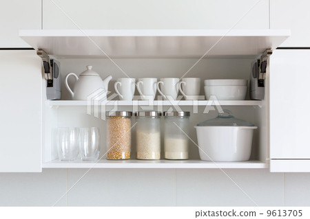 opened cupboard with kitchenware inside 9613705