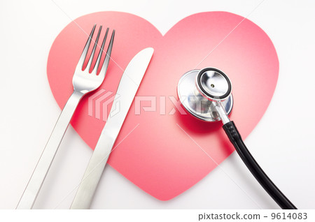 健康的飲食習慣。刀子/叉子和聽診器有心形的背景。 9614083