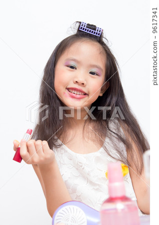 Little Asian child playing with mothers makeup Little Asian child playing with mothers makeup 9617341