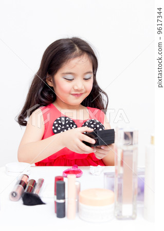 Little Asian child playing with mothers makeup Little Asian child playing with mothers makeup 9617344