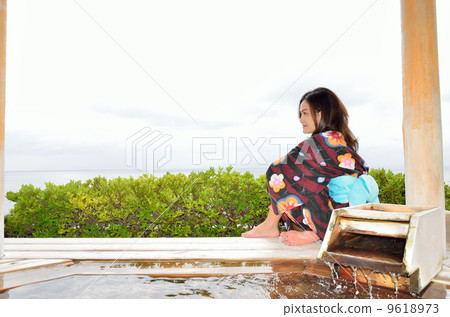 A woman sitting with an outdoor bath A woman sitting with an outdoor bath 9618973