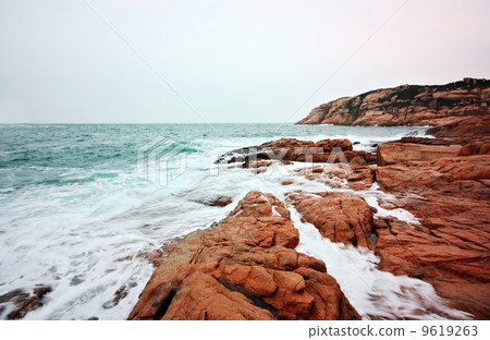 rocky sea coast and blurred water in shek o,hong kong 9619263