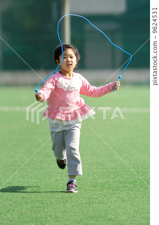 Girls running around while jumping rope 9624531