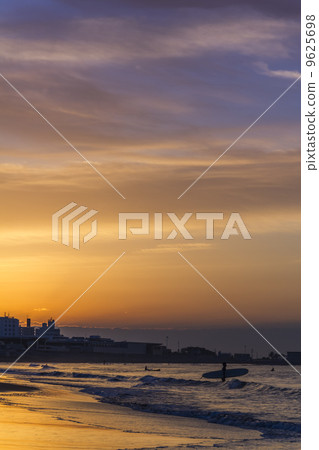 A surfer in the morning glow of Shonan Kinuma Coast 9625698