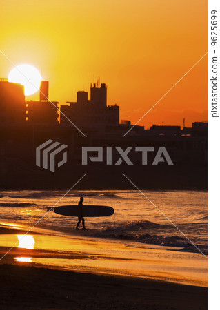 A surfer in the morning glow of Shonan Kinuma Coast 9625699