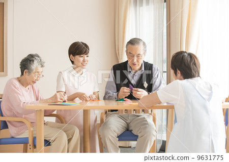 Senior and caregiver who enjoys origami 9631775