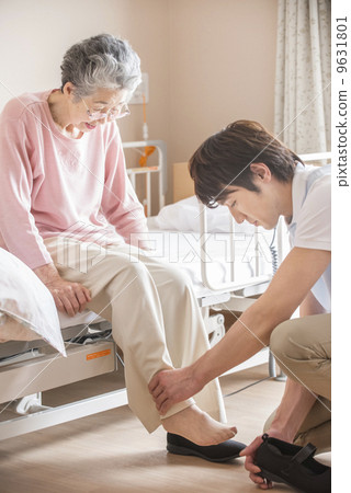 Male caregiver with elderly women's shoes on 9631801