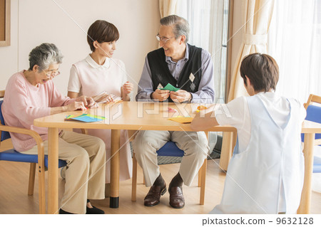Senior and nurse enjoying origami 9632128