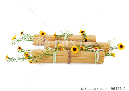 Uncooked Italian spaghetti decorated with yellow flowers isolate Uncooked Italian spaghetti decorated with yellow flowers isolate 9633141