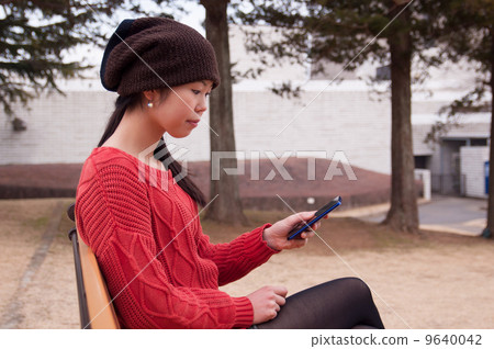 A woman watching a smartphone A woman watching a smartphone 9640042
