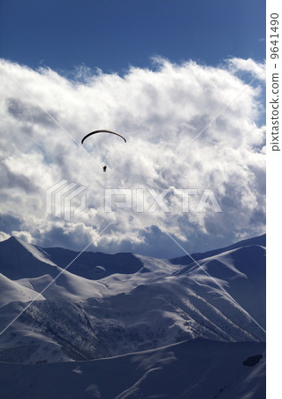 Winter mountain with clouds and silhouette of parachutist Winter mountain with clouds and silhouette of parachutist 9641490