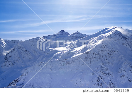 Snowy sunlight mountains, view from off piste slope Snowy sunlight mountains, view from off piste slope 9641539