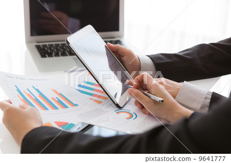 Close-up of  business team using digital tablet with financial d 9641777
