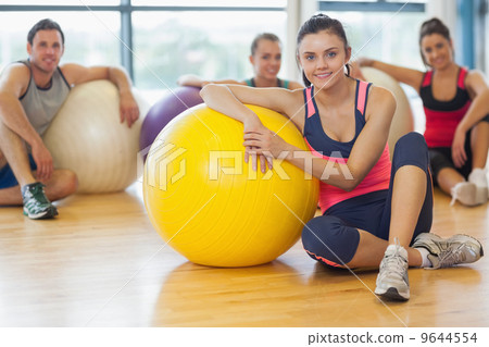 Instructor and fitness class with exercise balls at gym 9644554