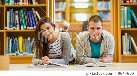 Students with books lying on the library floor Students with books lying on the library floor 9644690
