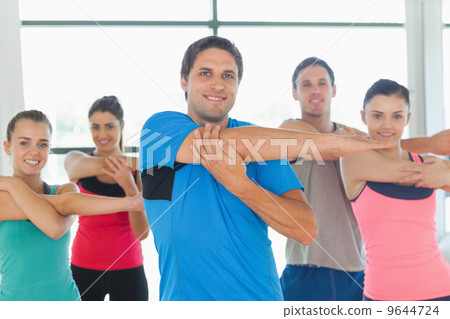 Portrait of sporty people stretching hands at yoga class Portrait of sporty people stretching hands at yoga class 9644724
