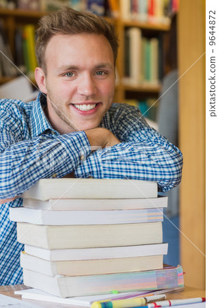 Male student with stack of books at library Male student with stack of books at library 9644872