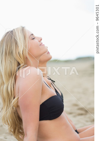Side view of two relaxed bikini women at beach Side view of two relaxed bikini women at beach 9645301