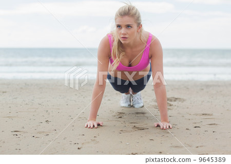 Beautiful woman doing push ups on beach Beautiful woman doing push ups on beach 9645389