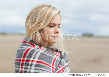 Side view of a woman covered with blanket at beach Side view of a woman covered with blanket at beach 9645585