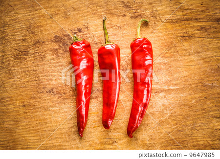 Red peppers on old wooden table 9647985