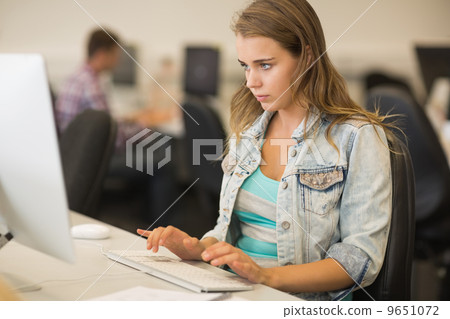 Focused young student working in the computer room Focused young student working in the computer room 9651072