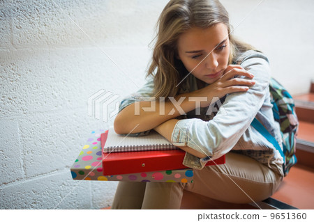 Sad student sitting on stairs 9651360