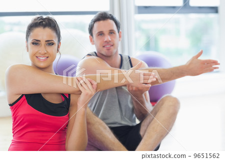 Two sporty people stretching hands at yoga class 9651562