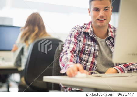 Cheerful student looking at camera in the computer room 9651747