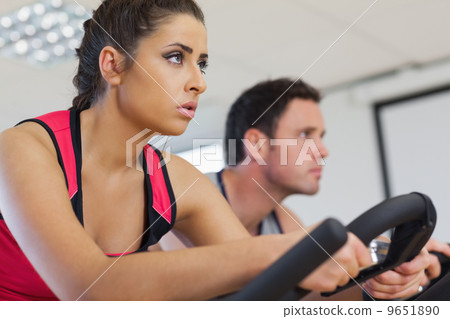 Young man and woman working out at spinning class Young man and woman working out at spinning class 9651890