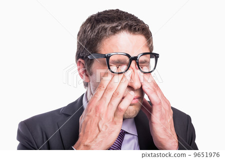 Close-up of a worried businessman rubbing eyes 9651976