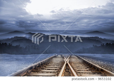 Train tracks leading to misty mountains 9653102