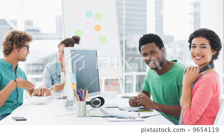 Artists working at desk in creative office 9654119