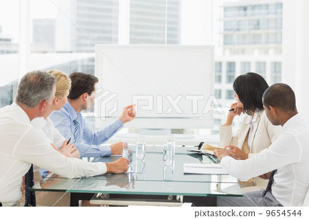 Business people looking at blank whiteboard in conference room 9654544