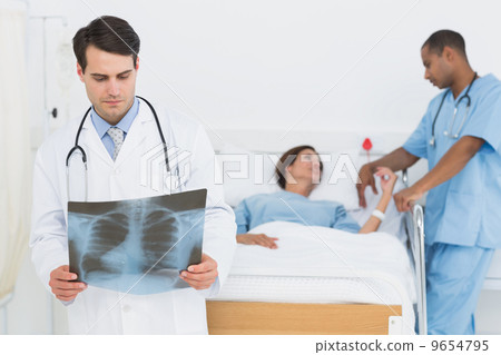 Doctor examining x-ray with patient in hospital Doctor examining x-ray with patient in hospital 9654795