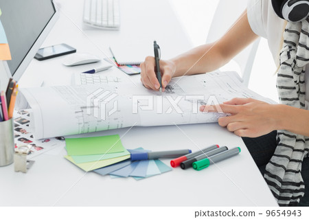 Artist drawing something on paper with pen at office Artist drawing something on paper with pen at office 9654943