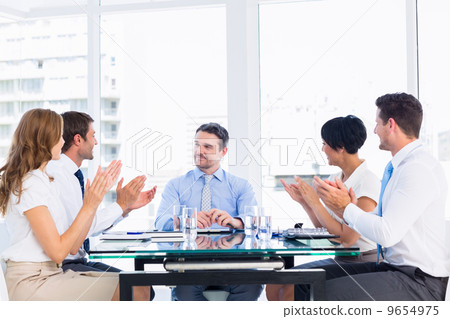 Executives clapping around conference table Executives clapping around conference table 9654975