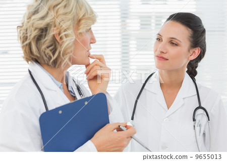 Two female doctors with medical reports 9655013