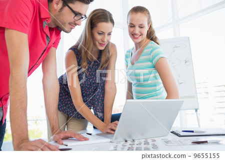 Casual business people using laptop in office Casual business people using laptop in office 9655155