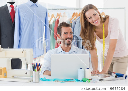 Fashion designers using laptop in studio Fashion designers using laptop in studio 9655284