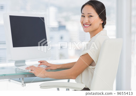 Young businesswoman using computer in office Young businesswoman using computer in office 9655413