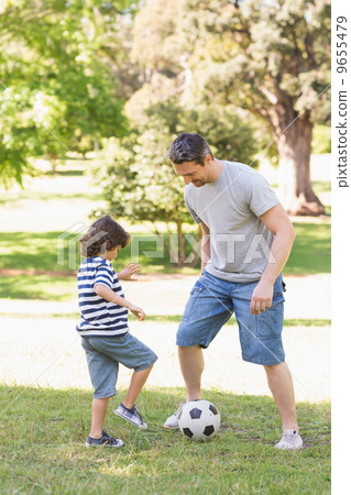 Father and son playing football in the park 9655479